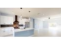 Modern kitchen with white cabinets, stainless steel appliances, and a center island with pendant lighting at 404 Miami Way, Kissimmee, FL 34759