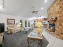 Comfortable living room featuring a stone fireplace, neutral carpeting, and a view into the adjacent kitchen at 409 N 6Th St, Lake Hamilton, FL 33851