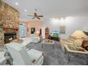 Inviting living room showcasing a stone fireplace, comfortable seating, and soft, neutral carpeting at 409 N 6Th St, Lake Hamilton, FL 33851