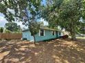 Single-story home with light blue exterior paint and mature trees and landscaping in the front yard at 4211 Sunny Land Dr, Lakeland, FL 33813