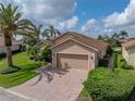 Attractive single-Gathering home with brick driveway, mature palm trees, and well-maintained landscaping at 4327 Gullane Dr, Lake Wales, FL 33859