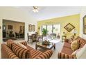 Cozy living room with high ceilings adjacent to a dining area and a view of the patio at 441 San Jose Dr, Winter Haven, FL 33884