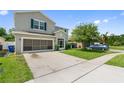Home featuring a two car garage with screened in door and landscaping at 476 Haines Trl, Winter Haven, FL 33881
