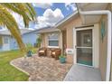 Inviting front entrance with comfortable seating, attractive potted plants, and a screened door at 492 Sweetwater Way, Haines City, FL 33844