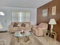 Cozy living room featuring plush seating, a glass coffee table, and natural light, ideal for relaxation at 5702 Breskin Dr, Orlando, FL 32839