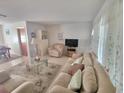 Bright living room with comfortable sofas, a glass table, and decorative curtains, creating a welcoming atmosphere at 5702 Breskin Dr, Orlando, FL 32839