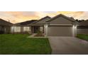 Inviting curb appeal of single-story home with a well-manicured lawn at sunset at 620 Jaxson Blvd, Winter Haven, FL 33880