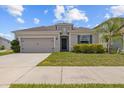 Single-story home with a two-car garage and a well-maintained lawn and trimmed landscaping at 622 Taft Dr, Davenport, FL 33837