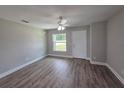 Bright living room featuring wood-look floors, ceiling fan, a large window, and a freshly painted interior at 628 Se Pine Ave, Fort Meade, FL 33841