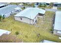 Aerial view of home featuring a metal roof, screened lanai, and spacious yard at 6470 Peppertree Ne Path, Winter Haven, FL 33881