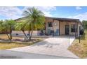 Inviting home showcasing palm tree landscaping, a covered carport, and a charming front patio area at 6470 Peppertree Ne Path, Winter Haven, FL 33881