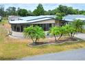 Beautiful property displaying mature palm trees, a screened lanai, and a well-maintained lawn at 6470 Peppertree Ne Path, Winter Haven, FL 33881