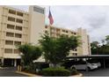 Exterior of condo building featuring an American flag and covered parking at 700 Mirror Nw Ter # 303, Winter Haven, FL 33881