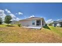 An exterior shot shows a home's backyard with a small patio and simple landscaping under a partly cloudy sky at 710 Persian Dr, Haines City, FL 33844