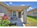 Cozy front porch features outdoor seating, a small garden and a walkway leading to the front door at 710 Persian Dr, Haines City, FL 33844