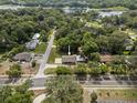 Aerial view of a home nestled among mature trees, showcasing its location near a lake at 1003 Bear Lake Rd, Apopka, FL 32703