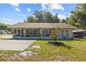 Inviting single-story home featuring a covered porch, landscaped yard, and neutral color palette at 1003 Bear Lake Rd, Apopka, FL 32703