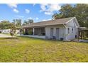 Attractive single-story home with a covered porch, complemented by lush green lawn at 1003 Bear Lake Rd, Apopka, FL 32703