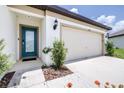 Home featuring a two-car garage, covered entry, and manicured landscaping at 1050 Michelangelo Ln, Winter Haven, FL 33884