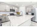 Modern kitchen features gray cabinets, stainless appliances, and a center island at 1050 Michelangelo Ln, Winter Haven, FL 33884