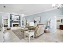 Bright living room with fireplace, tile floors, and beach-themed decor at 109 Lake Mariam Way, Winter Haven, FL 33884