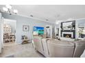 Open living room with fireplace, beach decor, view of dining room, and lots of seating at 109 Lake Mariam Way, Winter Haven, FL 33884