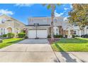 Well-kept home showcasing a two-car garage, arched windows, and a beautifully landscaped yard at 110 Minniehaha Cir, Haines City, FL 33844