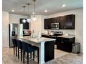 Modern kitchen featuring dark wood cabinets, stainless steel appliances, and pendant lighting at 1363 Benevento Dr, Winter Haven, FL 33884