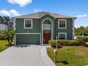 Charming two-story home with green exterior, white trim, neat lawn, and freshly paved driveway at 1800 Emily Dr, Winter Haven, FL 33884