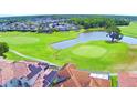 Scenic aerial view showcases the golf course community, lush greenery and pond at 2340 Pinehurst Ct, Davenport, FL 33837