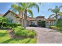 Inviting front exterior featuring lush landscaping, a brick driveway, and a charming entrance at 2340 Pinehurst Ct, Davenport, FL 33837