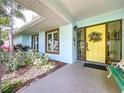 Inviting home entrance featuring a vibrant yellow door adorned with a beautiful floral wreath at 255 Lake Link Rd, Winter Haven, FL 33884
