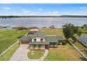 Aerial view of lakefront property featuring a well-maintained lawn, private dock, and multiple outbuildings at 2731 State Road 557, Lake Alfred, FL 33850