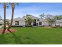 Beautifully landscaped home with a well-manicured lawn and mature palm trees at 2987 Plantation Rd, Winter Haven, FL 33884