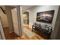 Hallway showcasing hardwood flooring and access to the laundry room, complimented by decorative pictures and a table at 3828 Eloise Estates Ct, Winter Haven, FL 33881