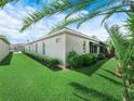 Lush backyard featuring a well-kept lawn, mature landscaping, and the side of the home at 4004 Sable Loop Dr, Lake Wales, FL 33859