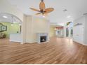 Open-concept living room featuring hardwood floors, a fireplace, and an open view of the foyer at 4004 Sable Loop Dr, Lake Wales, FL 33859