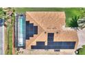 Aerial view of a home featuring a screened pool and solar panels on the roof at 4175 Muirfield Loop, Lake Wales, FL 33859
