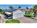View of a home with a brick driveway, showcasing solar panels and a convenient golf cart at 4175 Muirfield Loop, Lake Wales, FL 33859