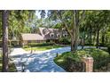Beautifully landscaped home with a long, curved driveway surrounded by mature trees, offering a private setting at 418 North Rd, Lakeland, FL 33809