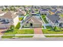 Aerial view of a home with solar panels, a well-kept lawn, and a brick-paved driveway at 428 Aragosa Dr, Davenport, FL 33837