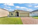 Charming one-story home featuring a well-maintained lawn and a brick-paved driveway at 428 Aragosa Dr, Davenport, FL 33837