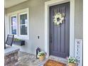 Charming front door with a decorative wreath, complementing the welcoming entrance and porch decor at 445 Waterfern Trail Dr, Auburndale, FL 33823