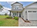 Inviting two-story home boasting a cozy front porch with seating and well-maintained landscaping at 445 Waterfern Trail Dr, Auburndale, FL 33823