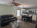 Inviting living room area featuring a comfortable black sofa, a unique glass-top coffee table, and an adjacent dining area at 4488 Turnberry Ln, Lake Wales, FL 33859