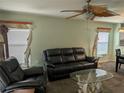 Bright living area with a comfortable sofa, tropical ceiling fan, and distinctive decorative elements creating a cozy atmosphere at 4488 Turnberry Ln, Lake Wales, FL 33859