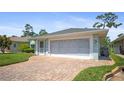 View of the home with brick driveway leading to a screened two-car garage at 469 Sweetwater Way, Haines City, FL 33844