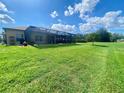 Expansive backyard with lush lawn and screened-in lanai, offering ample space for outdoor activities and relaxation at 5005 Pebble Beach Blvd, Winter Haven, FL 33884