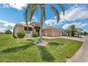 Attractive single-story home features a manicured lawn, fountain, and a brick-paved driveway leading to a two-car garage at 5005 Pebble Beach Blvd, Winter Haven, FL 33884