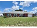 Beautiful single-story brick house with blue shutters and a well-maintained lawn on a sunny day at 504 W 7Th St, Frostproof, FL 33843
